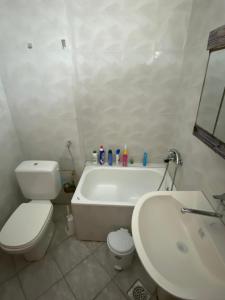 La salle de bains est pourvue de toilettes, d'une baignoire et d'un lavabo. dans l'établissement Struga Studio Appartment - 20 meters from the beach, à Struga