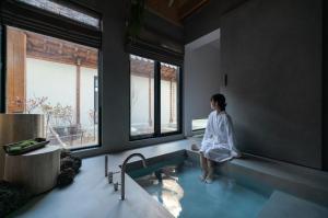 uma mulher sentada numa banheira na casa de banho em Han Yul Jae - Hanok em Chuncheon