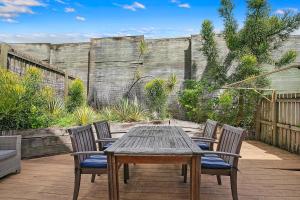 a wooden table and chairs on a patio at The Sunny Studio - A Peaceful Riverside Abode in Brisbane