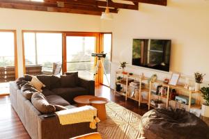 sala de estar con sofá y mesa en Mountain Retreat with ocean views, en Kin Kin
