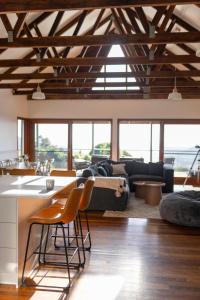 sala de estar con sofá, mesa y sillas en Mountain Retreat with ocean views, en Kin Kin