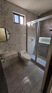 een badkamer met een douche, een toilet en een wastafel bij Casa Madero in Ciudad Madero