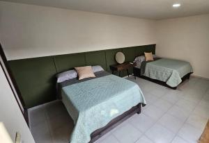 een kamer met 2 bedden en een spiegel aan de muur bij Casa Madero in Ciudad Madero