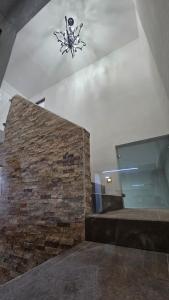 een kamer met een bakstenen muur en een kroonluchter bij Casa Madero in Ciudad Madero