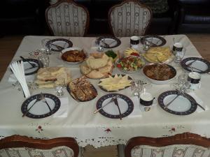 a table with a white table cloth with food on it at Guest House Vivaushba in Bagvdanari