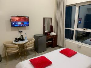 Habitación de hotel con cama, mesa y TV. en Family rooms with beach view, en Ajman
