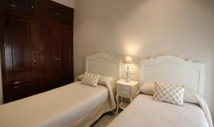 - une chambre avec deux lits et une lampe sur une table dans l'établissement Hotel Maestranza, à Séville
