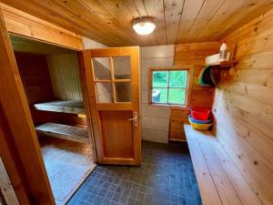 Your Cutest Saaremaa Escape and Sauna. Very Private. في Ruhve: غرفة بجدران خشبية وباب في كابينة