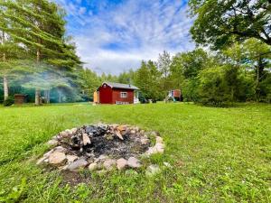 una hoguera en un campo con un granero rojo en Your Cutest Saaremaa Escape and Sauna. Very Private., en Ruhve