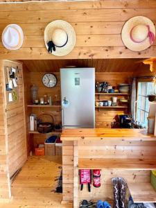 Your Cutest Saaremaa Escape and Sauna. Very Private. في Ruhve: مطبخ مع ثلاجة وقبعات على الحائط
