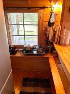 cocina con 2 ollas en una estufa y ventana en Your Cutest Saaremaa Escape and Sauna. Very Private., en Ruhve