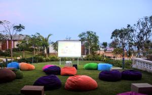 a group of colored bean bags on the grass with a screen at TTC Van Phong Bay Resort - Himalaya Sauna & Steam Retreat Included in Ninh Hòa