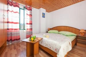 Un dormitorio con una cama y una mesa con fruta. en Secluded holiday house Zivogosce - Mala Duba, Makarska - 19811, en Igrane