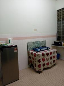 Habitación con mesa y silla en la cocina en Nawlaa Homestay en Melaka