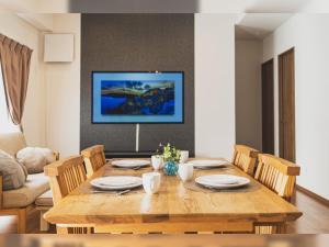 - une salle à manger avec une table et des chaises en bois dans l'établissement Comfort Plus, à Chatan