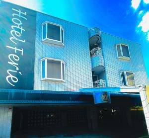 un edificio de ladrillo azul con un cartel. en ホテル フェリエ hotel for adults, en Hachioji