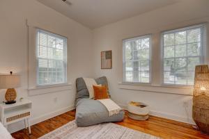 sala de estar con sofá gris y ventanas en Peaceful Park Circle Getaway, en Charleston