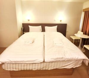 Postel nebo postele na pokoji v ubytování Prom Ratchada Hotel