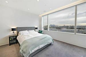 una camera con un letto e una grande finestra di River London City Views Large Sub penthouse a Londra