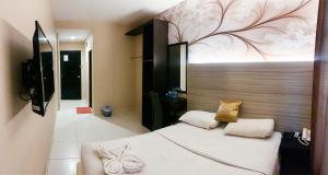 a bedroom with a white bed with a flower mural on the wall at OS Hotel Batu Aji Batam in Batam Center