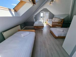a attic room with two beds and a couch at City SuperHost - Peaceful Home in Salford in Manchester