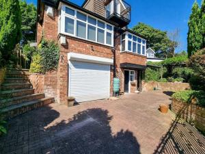 a brick house with a garage and a driveway at City SuperHost - Peaceful Home in Salford in Manchester