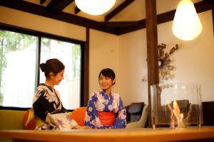 zwei Frauen in Kimonos, die an einem Tisch sitzen in der Unterkunft Yumenoi in Himeji