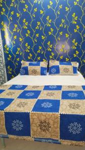 Una cama con un edredón azul y amarillo. en Sunshinehomes en Chennai