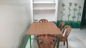 una mesa de madera y sillas en una habitación en Sunshinehomes en Chennai
