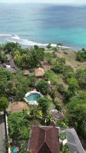 een luchtzicht op een resort met een zwembad en de oceaan bij Bodhi Bingin in Uluwatu