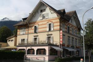 a large building with a balcony on a street at Hotel de la Gare in Monthey