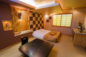 Un dormitorio con una cama y una mesa. en EIGHT PRINCE HOTEL -Adult Only- en Tokorozawa