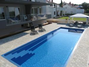 a large blue swimming pool next to a house at House Barbara in Banjole