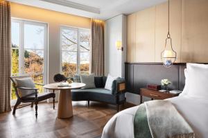 um quarto de hotel com uma cama, uma mesa e uma cadeira em Rosewood Schloss Fuschl em Hof bei Salzburg
