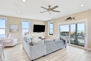 a living room with a couch and a flat screen tv at The Minty Pearl in Mexico Beach
