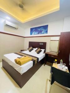 a hotel room with two beds and a mirror at RAINBOW ROOMS in Kozhikode