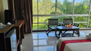 una habitación de hotel con mesa y sillas en una habitación en The Pano Hotel And Residence, en Ban Khlong Haeng