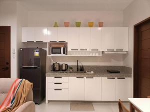 a kitchen with white cabinets and a black refrigerator at JD&S Apartments Unit 4 in Iligan