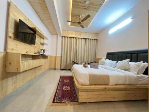 1 dormitorio con 1 cama y TV de pantalla plana en Hotel Cloud Hills Mcleodganj en McLeod Ganj