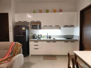 a kitchen with white cabinets and a black refrigerator at JD&S Apartments Unit 4 in Iligan City +38 photos