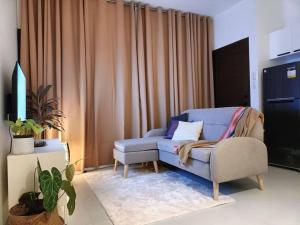 a living room with a blue chair and curtains at JD&S Apartments Unit 4 in Iligan