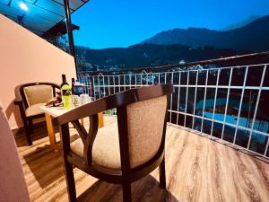 Un balcón con una mesa con botellas de vino. en Hotel Cloud Hills Mcleodganj en McLeod Ganj