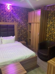 sypialnia z łóżkiem i krzesłem w obiekcie FORTUNE PEARL HOTEL w mieście Lagos