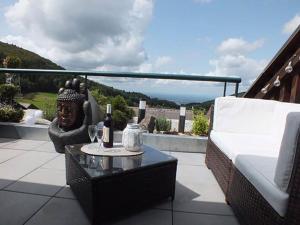 un patio con sofá y una mesa con botellas de vino en Nice apartment in Sasbachwalden en Sasbachwalden