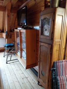 Zimmer mit einer Großvater-Uhr und einem TV in der Unterkunft Marmotte 2 in Ornon