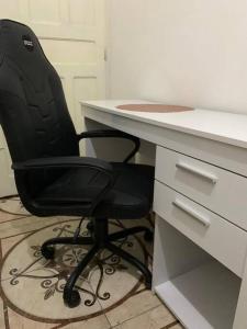 a black office chair sitting in front of a desk at Casa E-House Manaus in Manaus