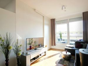 ein Wohnzimmer mit einem TV und einem großen Fenster in der Unterkunft Beachfront penthouse in Binz in Binz