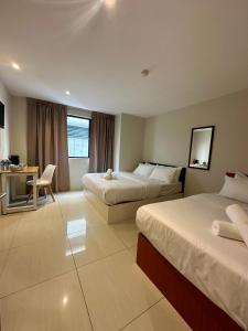 Pokój hotelowy z 2 łóżkami i biurkiem w obiekcie Swing & Pillows - KL Pekeliling formerly known as Swiss Cottage Hotel w Kuala Lumpur