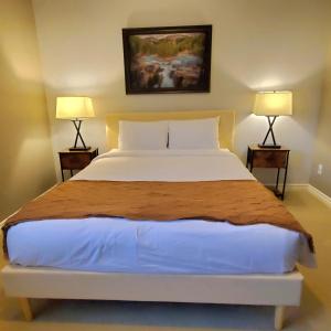 a bedroom with a large white bed with two lamps at Private suite with AC Near Cultus Lake and Heritage Park in Chilliwack