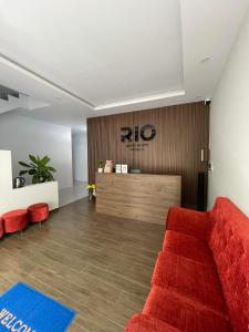 a living room with a red couch and a counter at Rio Guest House - Phú Quốc in Phú Quốc